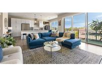 Bright living room featuring a modern blue couch, white kitchen, and balcony access with views at 22 Airline Ne St # 403, Atlanta, GA 30312