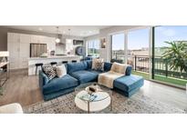 Bright living room with a blue sectional sofa, open to the kitchen and a balcony with black railing at 22 Airline Ne St # 403, Atlanta, GA 30312