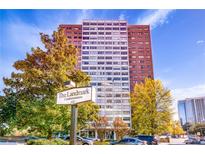 The Landmark Condominiums is a high-rise with a sign, trees, and a few cars parked in front of the building at 215 Piedmont Ne Ave # 204, Atlanta, GA 30308