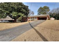 Traditional brick home featuring mature tree, covered entrance, and driveway at 2798 Tralyn Ct, Decatur, GA 30034