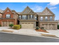 Charming townhome with a two-car garage, landscaping, and attractive architectural details at 5619 Cobblestone Creek Ave, Mableton, GA 30126