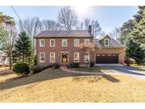 Charming two-story brick home with a well-manicured lawn and attached two car garage at 1645 Dunwoody Sq, Dunwoody, GA 30338