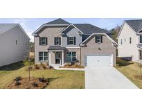 Charming two-story home with a well-maintained front lawn, brick facade, black shutters, and a two-car garage at 1808 Lacebark Elm Way, Lawrenceville, GA 30045