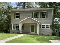 Charming two-story home with green shutters, a front porch, and a well-maintained lawn at 577 Center Hill Nw Ave, Atlanta, GA 30318