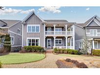 Charming two-story home with a welcoming double-decker porch and beautifully landscaped front yard at 2304 Isla Run, Woodstock, GA 30188