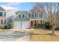 Charming two-story home featuring a two-car garage, manicured lawn, and inviting red front door at 6280 Whirlaway Dr, Cumming, GA 30040