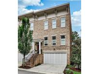 Beautiful brick townhome with attached two-car garage and landscaped entryway and stairs at 1180 John Collier Rd, Atlanta, GA 30318