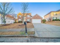 Charming two-story brick home with a well-manicured front yard and a two-car garage at 2397 Shady Maple Trl, Loganville, GA 30052