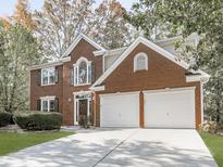 Charming two-story brick home with a well-maintained lawn and attached two-car garage at 1633 Moonlake Nw Trl, Kennesaw, GA 30152