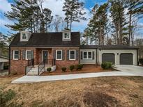 Charming brick home with a well-manicured lawn and an attached two-car garage at 6390 E Stubbs Rd, Atlanta, GA 30349