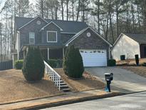 Charming two-story home with stone facade, attached garage, landscaped front yard and a classic suburban appeal at 1440 Steam Engine Way, Conyers, GA 30013