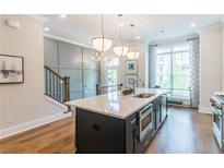 Modern kitchen island with white countertop, stainless steel appliances, and stylish pendant lighting at 3117 Moor View Rd # 36, Duluth, GA 30096