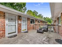 View of the cozy brick condo patio with outdoor seating and greenery under a clear blue sky at 343 8Th Ne St # G2, Atlanta, GA 30309