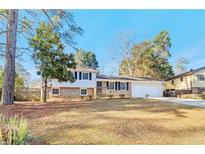 Charming home with a mix of brick and siding, a well-maintained lawn and established trees at 6071 Cristie Dr, Ellenwood, GA 30294