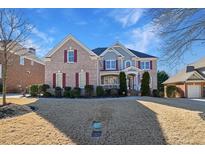 Charming two-story brick home with a manicured front yard and inviting entrance at 2621 Trailing Ivy Way, Buford, GA 30519