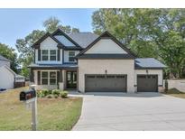 Beautiful two-story home featuring brick and white siding, a three-car garage and a well-manicured lawn at 58 Cherry St, Lawrenceville, GA 30046