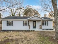 Charming single-story home with neutral siding and dark shutters, complemented by mature trees and a well-kept lawn at 1487 Arnold Dr, Lawrenceville, GA 30043