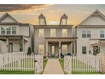 Charming two-story home featuring gray siding, white trim, and a welcoming front porch and fence at 613 Everett Ln, Woodstock, GA 30188