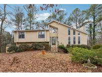 Inviting front exterior featuring a unique architectural design and natural stone accents at 6664 Windwood Cir, Douglasville, GA 30135