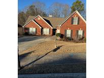 Charming red brick home with a well-manicured lawn and a concrete driveway, and a two car garage at 1176 Whatley Mill Ln, Lawrenceville, GA 30045