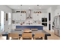 Modern kitchen with stainless steel appliances, white cabinets, and a large center island with pendant lighting at 335 Tillman Pass, Woodstock, GA 30188