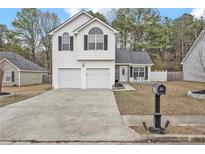 Charming two-story home featuring a well-maintained lawn and a two-car garage at 4750 Millenium View Ct, Snellville, GA 30039