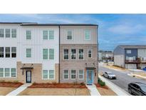 Charming townhome exterior with brick and white siding, plus a bright blue front door at 2212 Whistler Ne Way, Lawrenceville, GA 30043
