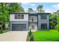 Two-story modern home with a two-tone exterior, balcony, large windows, and well-maintained landscaping at 921 Cone Rd, Forest Park, GA 30297