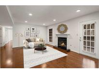 Bright living room with a fireplace, hardwood floors, modern decor, and a white rug at 2116 N Forest Trl, Atlanta, GA 30338