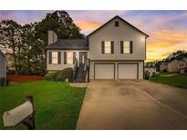 Charming two-story home featuring a well-manicured lawn and a two-car garage at 6230 Nellie Se Br, Mableton, GA 30126
