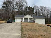 Charming single Gathering home with a well-maintained front yard and attached one car garage at 4567 Duncan Dr, Sugar Hill, GA 30518