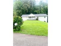 Charming single-story home with a well-maintained lawn and mature trees at 4567 Duncan Dr, Sugar Hill, GA 30518