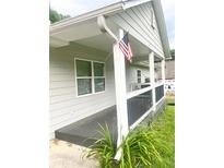 Inviting front porch featuring painted wood deck, siding and an American flag at 4567 Duncan Dr, Sugar Hill, GA 30518