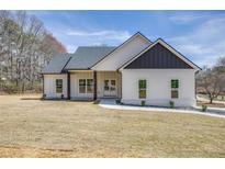 Charming one-story home with white siding, black accents, large front lawn, and a paved walkway to the front door at 1270 Sandhill Hulett Rd, Villa Rica, GA 30180