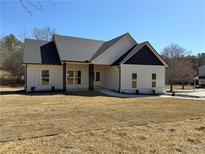 Charming single-story home with white siding, dark roof, and well-manicured front lawn on a sunny day at 1270 Sandhill Hulett Rd, Villa Rica, GA 30180