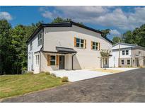 Modern two-story home with a white brick facade, wood shutters, and a well-manicured lawn at 2387 Highpoint Rd, Snellville, GA 30078