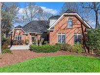 Beautiful brick home featuring a manicured lawn and mature landscaping at 4051 Ridgehurst Se Dr, Smyrna, GA 30080
