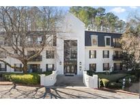 Beautiful condo building with white facade, black shutters, and manicured landscaping, offering a stylish and inviting entrance at 3110 Pine Heights Ne Dr, Atlanta, GA 30324