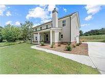 A charming two-story home features a covered porch, manicured lawn, and a private driveway at 878 Forrester Cemetery Rd, Covington, GA 30014