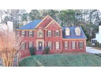 Two-story brick home with a blue roof, dormer windows, and manicured front lawn at 420 Woodbrook Way, Lawrenceville, GA 30043
