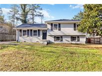 Charming split-level home with freshly painted white brick and dark shutters on a sunny day at 8331 Attica Ct, Jonesboro, GA 30238