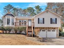 Charming home with a two-car garage, wood deck, stone accents, and mature landscaping at 1117 Mountain Springs Nw Dr, Kennesaw, GA 30144