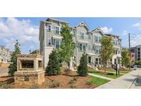 Gray townhome with manicured front lawn and entrance sign at Townes at Asbury community at 204 College Cir # 1003, Hapeville, GA 30354