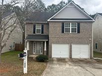 Charming two-story brick home with an attached two-car garage and well-maintained landscaping at 3999 Riverside Pkwy, Decatur, GA 30034