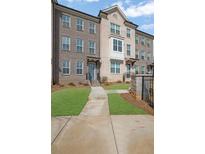 Charming brick townhome features manicured lawn, and inviting entryway at 225 Sims Park Pl, Suwanee, GA 30024