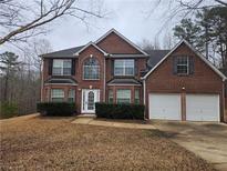 Charming brick two-story home featuring an attached two-car garage and manicured landscaping at 4667 Derby Loop, Fairburn, GA 30213
