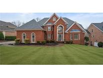 Stunning brick home with lush lawn, mature landscaping, and a stately, symmetrical facade at 3428 Stembler Rdg, Douglasville, GA 30135