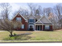 Charming two-story home with brick and siding, green shutters and a well-manicured lawn at 3641 Willow Club Dr, Loganville, GA 30052