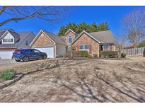 Charming single-story house featuring a stone facade, attached garage and blue car in the driveway at 1241 Skylar Ridge Cir, Buford, GA 30519