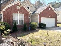 Charming brick home with a well-maintained lawn and two-car garage at 396 Avian Forest Dr, Stockbridge, GA 30281